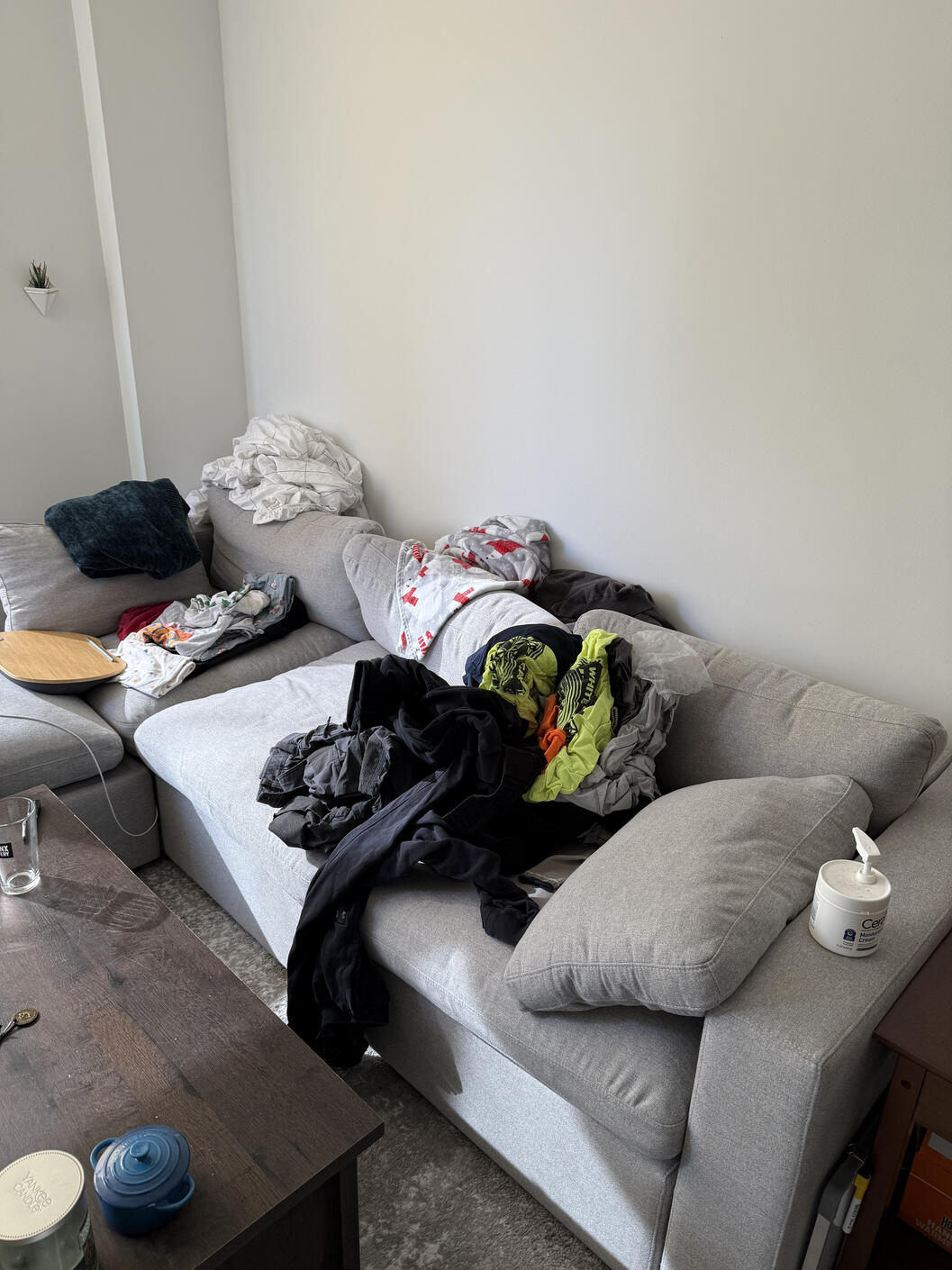 Couch BEFORE With Clothes Needing to be Folded